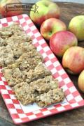 Baked Apple Bars with oatmeal crumble on top are displayed on a platter.
