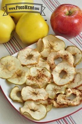 Slices of dried apples sprinkled with cinnamon are displayed on a platter.