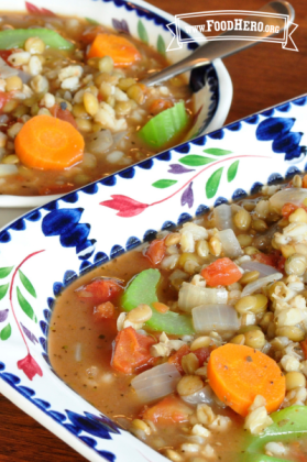 Bowls of soup containing colorful vegetables, lentils and barley.