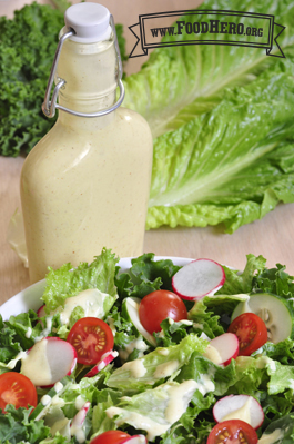 Bottle of dressing displayed with a salad.