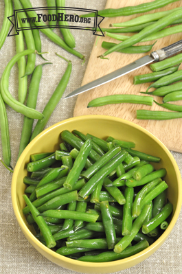 Bowl of green beans coated with sauce. 