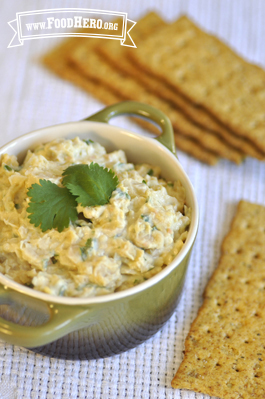 Garbanzo bean dip garnished with cilantro and served with crackers. 