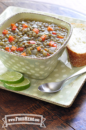 Lentil, carrot and bell pepper soup served with lime and a slice of bread.