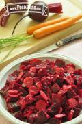 Sliced carrots and beets are mixed with a light dressing and displayed in a salad bowl.