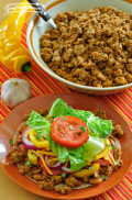 Un tazón con chorizo acompañado con una ensalada fresca.
