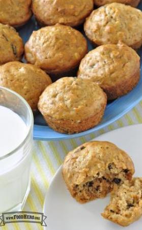 Golden muffins with raisins served with a glass of milk.