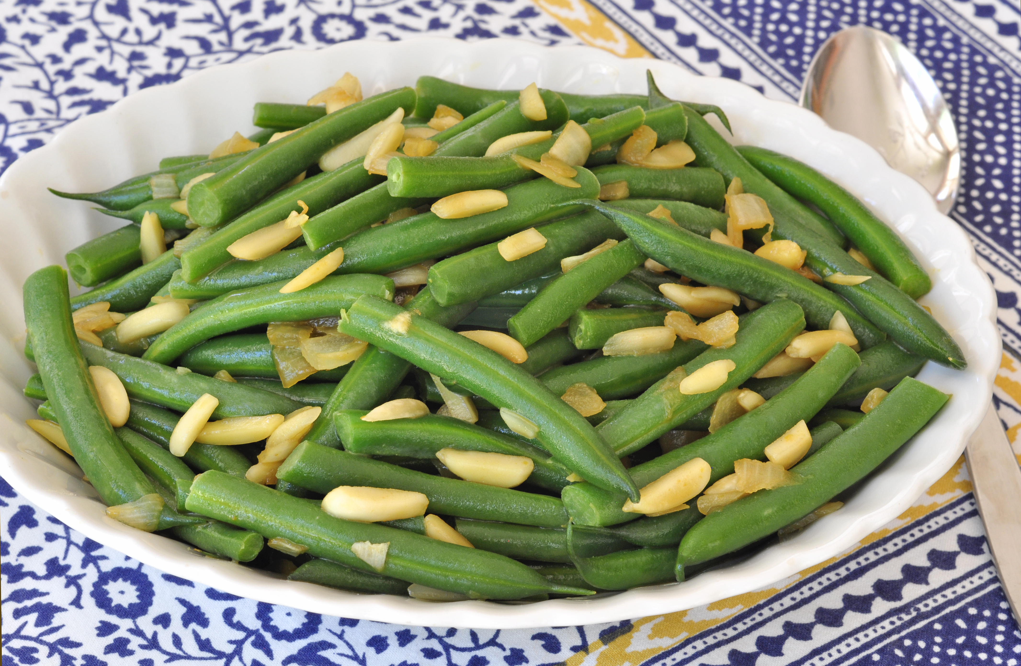 green beans with onions and almonds served in bowl