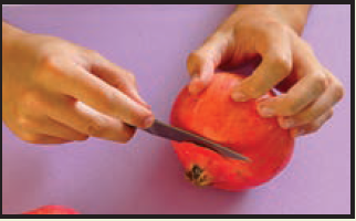 cutting top of pomegranate