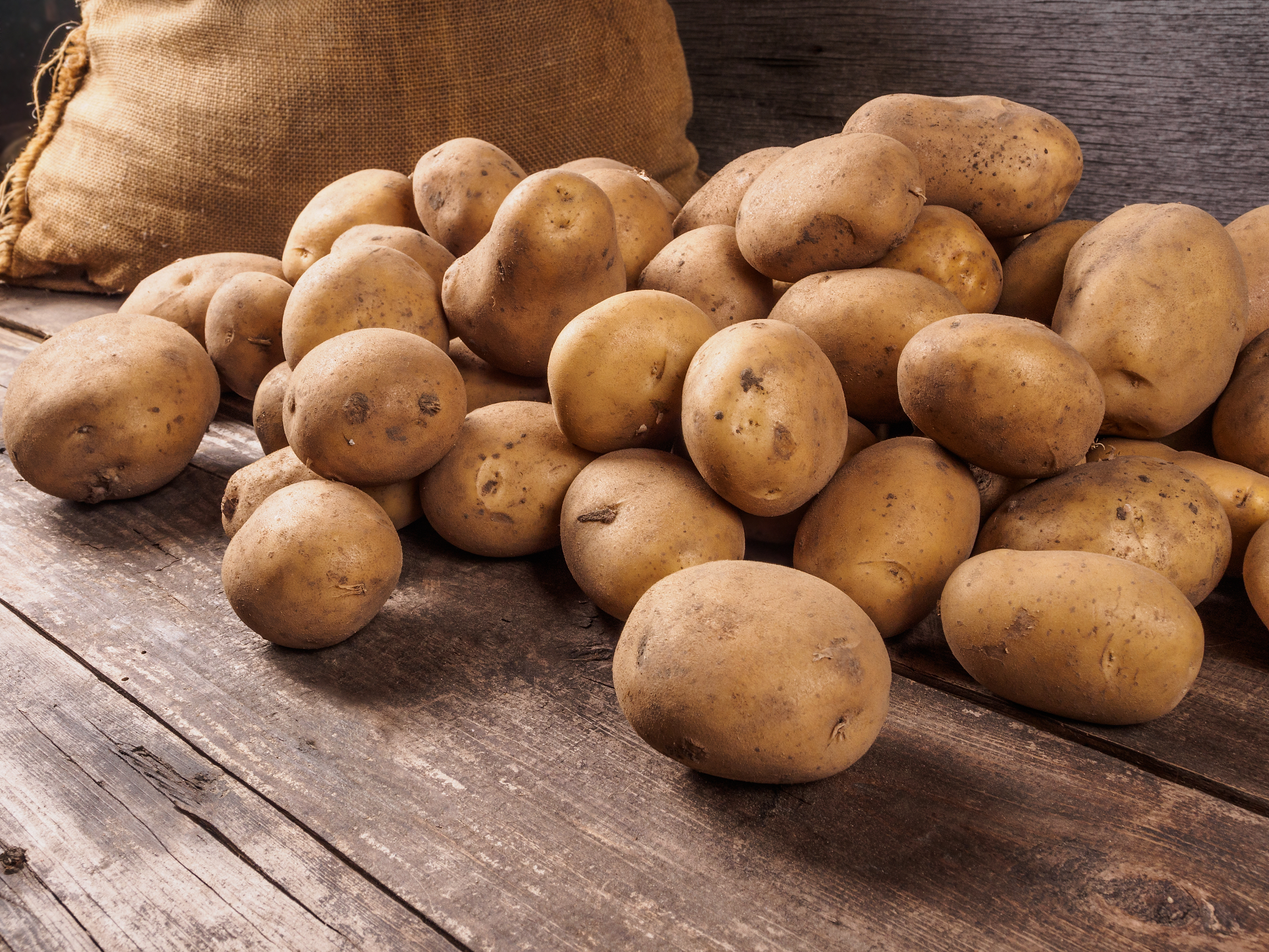 Potatoes next to storage bag on table