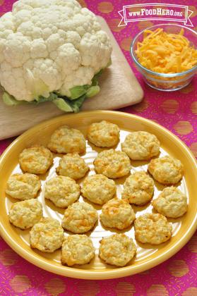 Baked rounds of chopped cauliflower and cheese are shown on a platter.