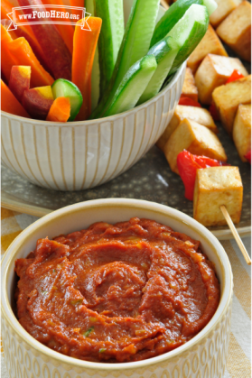 A bowl of banana ginger sauce is shown with raw veggie strips and grilled tofu kebabs for dipping.