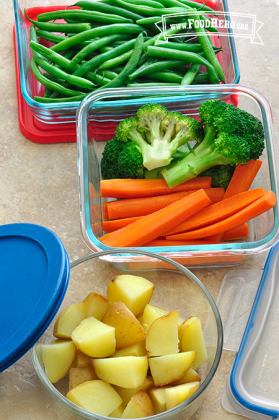 Glass containers with potatoes, carrots, broccoli and green beans.