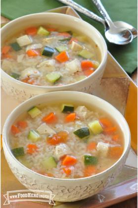 Dos tazones de sopa rellenos de arroz, pollo y verduras.