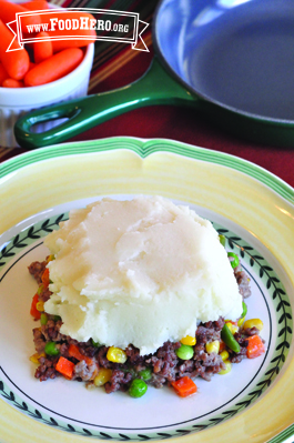 Plate of a ground beef and vegetable mix with a layer of mashed potato on top.