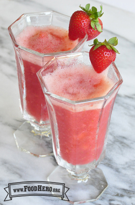Frothy pink strawberry drinks in glasses. 