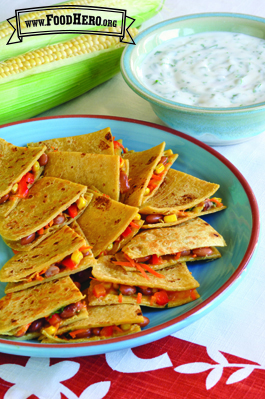 Corn tortillas folded over vegetables and cheese served with a yogurt dip.
