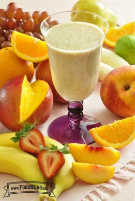 Creamy fruit smoothie in a footed glass.