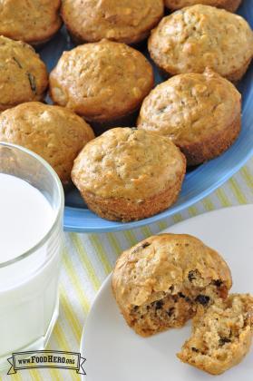 Golden muffins with raisins served with a glass of milk.