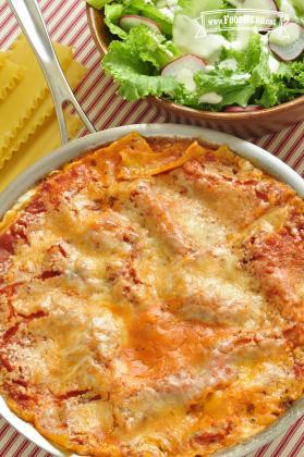 Skillet of layered flat pasta, beef, sauce and cheese.