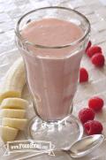 Creamy pink banana-raspberry smoothie is shown in a serving glass.