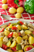 Tazón lleno con papas al horno del tamaño de un bocado, pollo y chiles campanas.
