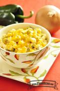 Bowl of hominy and green chiles with a layer of melted cheese on top.