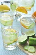Glasses of water with floating cucumber, lime and lemon slices.