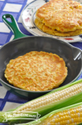 Panqueques de maíz dorados y redondos en un sartén y un plato.