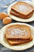 Plates of French Toast dusted with powdered sugar.