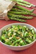Sauteed asparagus slices with slivered almonds in a small bowl. 