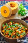Vibrant harissa roasted butternut squash in a wooden bowl topped with fresh mint and cilantro 