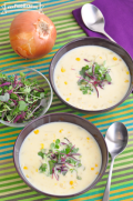 Bowls of creamy corn soup garnished with microgreens. 