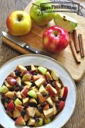 Bowl of baked apple chunks with raisins and cinnamon.
