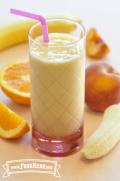 Glass of a creamy orange smoothie with a straw.