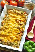 Casserole dish with rice, beef and vegetables with melted cheddar cheese.
