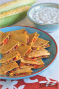 Tortillas de maíz dobladas sobre verduras y queso servidas con dip de yogurt.