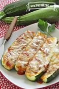 Plate of baked zucchini halves filled with red sauce and melted cheese.
