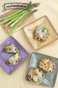 English muffins topped with chopped asparagus, mushrooms and broiled cheese are shown on plates.
