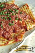 Plate of stuffed cheese pasta with red sauce and fresh parsley.