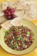 Medium bowl of grape salsa shown with tortilla chips.