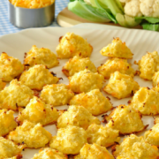 Rodajas horneadas de coliflor picada y queso se muestran en un plato.