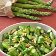 Sauteed asparagus slices with slivered almonds in a small bowl. 