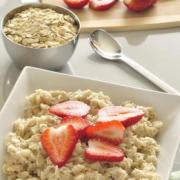 Bowl of oats served with sliced strawberries.