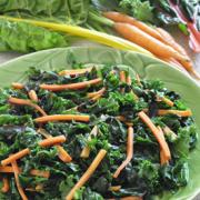 Plate of kale and carrot strips with dressing. 