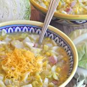 Small bowls of potato and ham soup with shredded cheese.