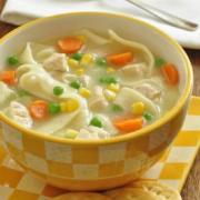 Bowl of chicken noodle soup served with crackers. 