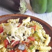 Rotini noodles with vegetables and shredded cheese.