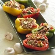 Platter of multicolored baked bell peppers stuffed with ground turkey, vegetables and mushrooms.