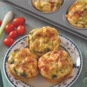 Plate of golden baked egg, vegetable and cheese quiches. 