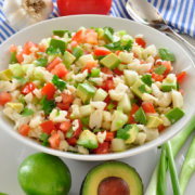 Bowl of colorful diced vegetables with dressing.